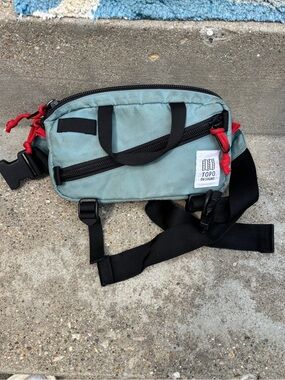 Topo Designs Sage Green Waist Pack with Black Strap and Red Zipper Pulls